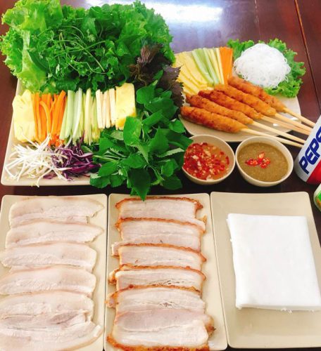 Banh trang cuon thit heo features rice paper rolls filled with grilled pork and various ingredients.